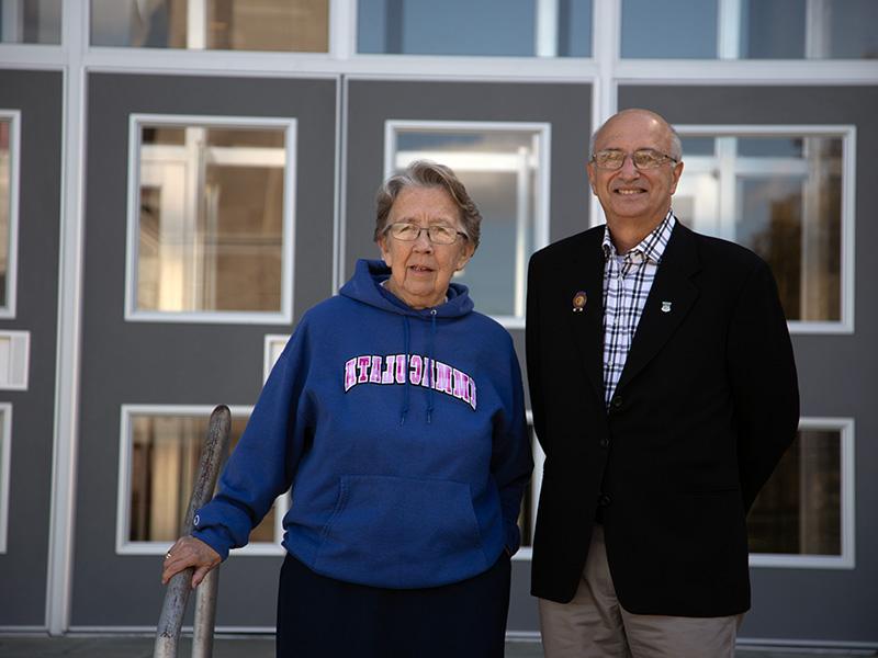 Older man and woman standing in front of building